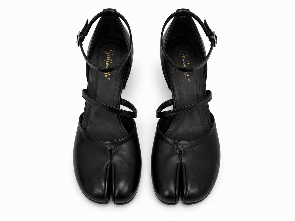 A pair of black leather tabi-style heeled sandals with ankle straps, shown from a top-down view on a white background. The brand name 'Sakura K' is printed in gold on the insole.